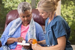 nurse selecting medicine for senior woman